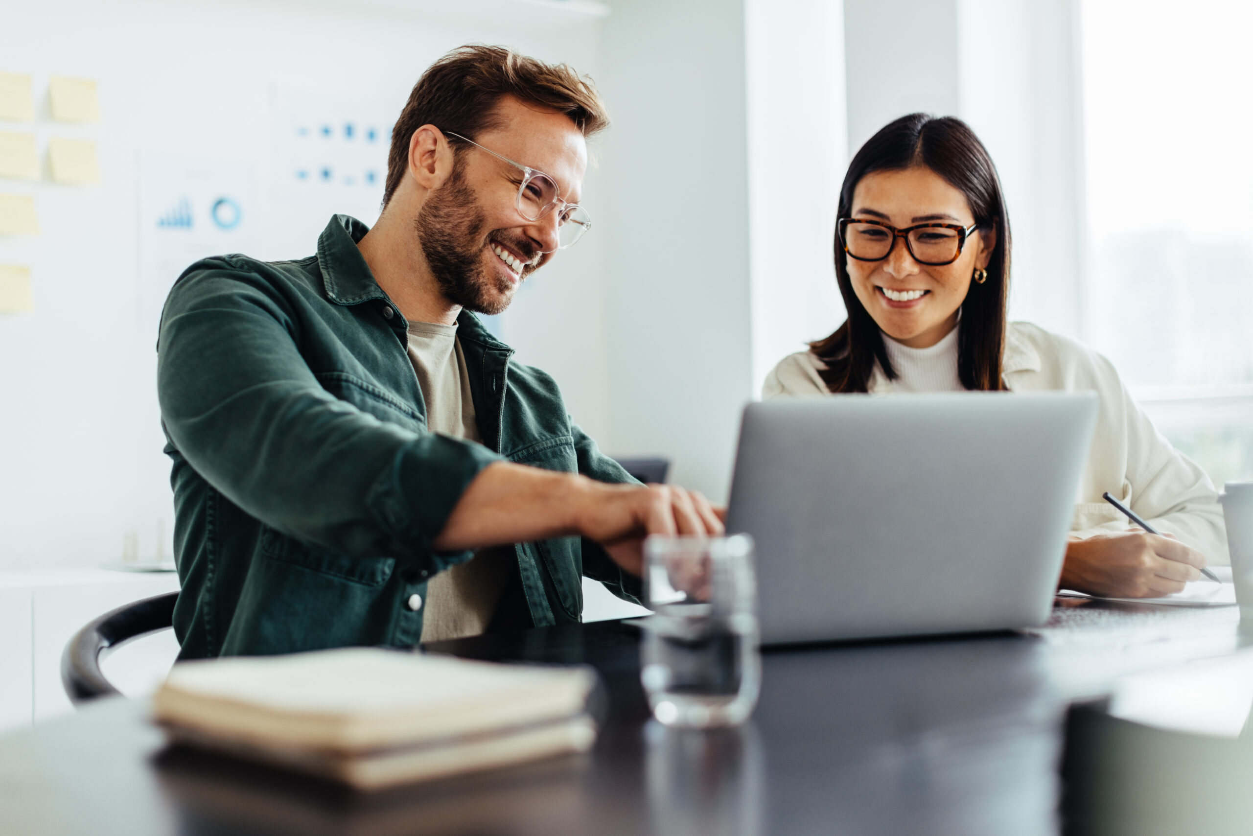 Two business people using a laptop together in an office
